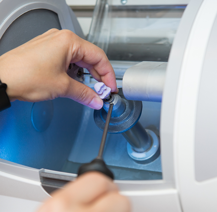 Dentist putting ceramic block into CEREC machine