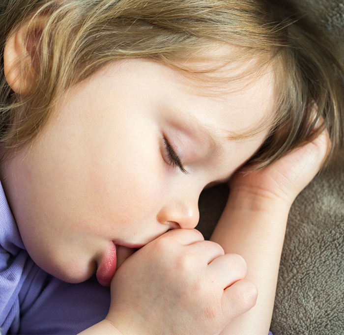 Close up of young child sucking their thumb