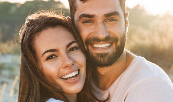 Man and woman standing together outside and hugging