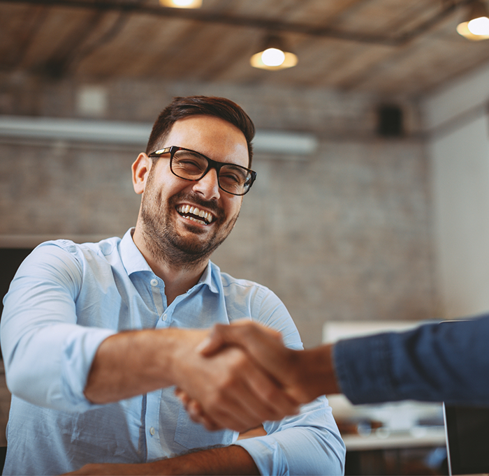 Man with glasses shaking someones hand