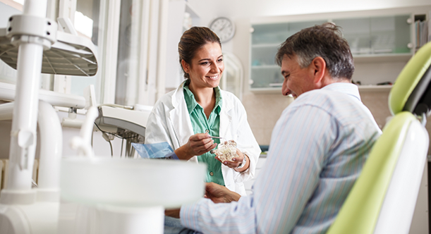 Female dentist and senior male dental patient