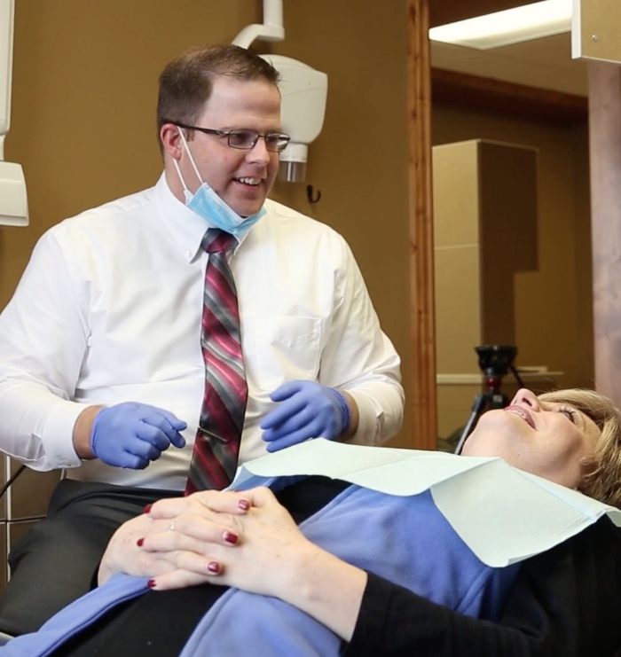 Dr Jenkins talking to dental patient while they are lying down in dental chair