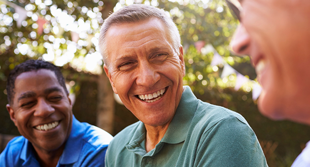 Three men sitting and smiling at each other