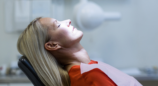 Woman in dental chair sitting back and relaxing