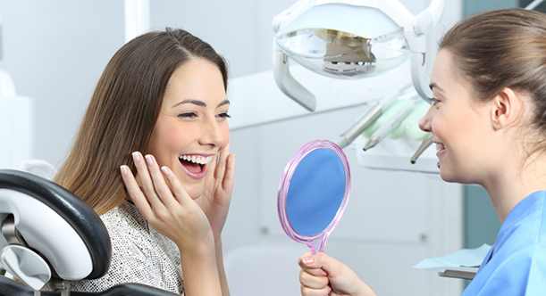 Dentist showing patient improved smile in mirror