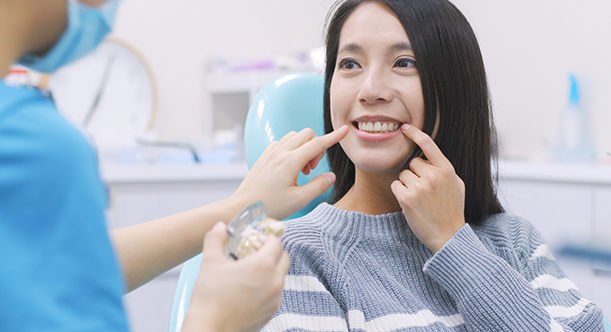 Woman sitting in dental chair and smiling