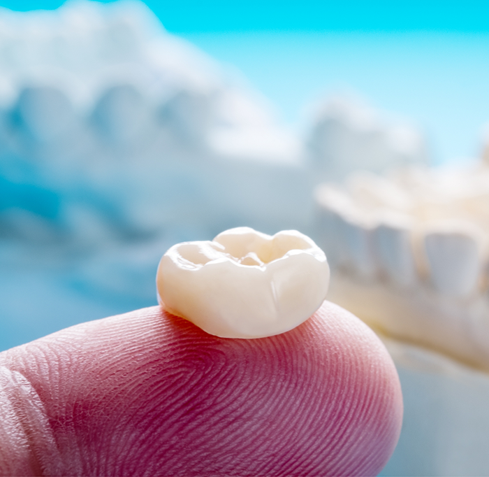 Close up of dental crown on finger